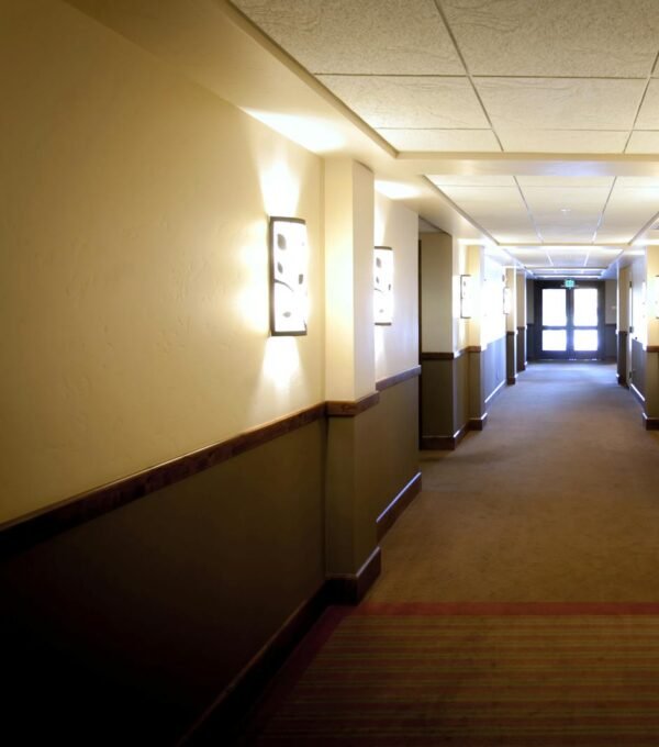 Bright hotel hallway in Boise, Idaho, showcasing elegant wall lighting and modern design.