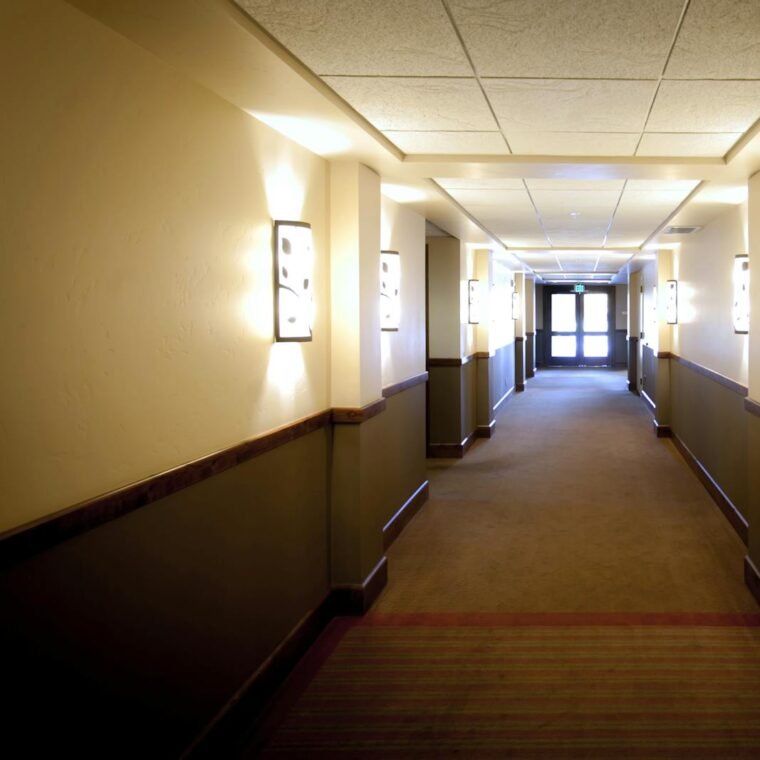 Bright hotel hallway in Boise, Idaho, showcasing elegant wall lighting and modern design.