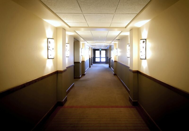 Bright hotel hallway in Boise, Idaho, showcasing elegant wall lighting and modern design.